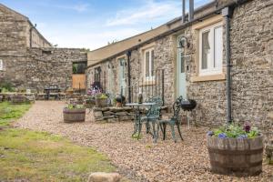 a patio with chairs and a table in front of a building at 1 Bed in Middleham oc-c30871 in Gammersgill