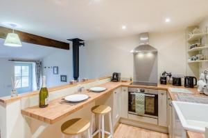 a kitchen with a counter with two stools at 1 Bed in Middleham oc-c30871 in Gammersgill