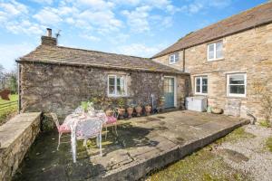 a stone house with a table and chairs in front of it at 2 Bed in Harmby oc-t30971 in Hornby