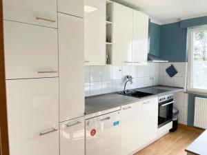 a white kitchen with white cabinets and a sink at Apartments Hemer in Hemer