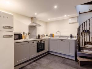 a large kitchen with white cabinets and a sink at 1 Bed in Frome oc-83834 in Holwell +6 photos