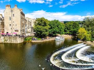 a boat traveling down a river in a city at 1 Bed in Frome oc-83834 in Holwell