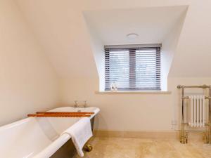 a bathroom with a bath tub and a window at 1 Bed in Frome oc-83834 in Holwell