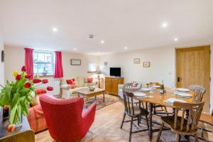 a living room with a table and red chairs at 3 Bed in Middleham oc-o32119 in Gammersgill