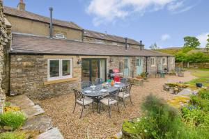 a patio with a table and chairs in front of a house at 3 Bed in Middleham oc-o32119 in Gammersgill