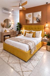 a bedroom with a large bed with a yellow headboard at Fairview Holiday Villa in Rivière Noire