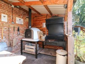 a outdoor kitchen with a stove in a brick wall at 1 Bed in Rocester oc-e33057 in Rocester