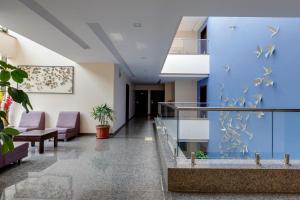 a hospital lobby with a blue wall with birds on it at Hotel Silver Oak 7 Minutes Walk to Mahalaxmi Temple in Kolhapur