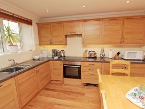 a kitchen with wooden cabinets and a wooden table at 3 Bed in Bamburgh oc-cn222 in Warenford