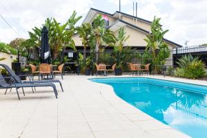a patio area with chairs, a pool and a pool table at Best Western Bungil Creek Motel in Roma
