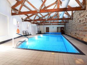 a large swimming pool in a building with a brick wall at 3 Bed in Bamburgh oc-cn222 in Warenford