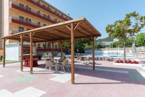 a wooden pavilion with chairs and tables in a patio at BLUESEA Continental in Tossa de Mar