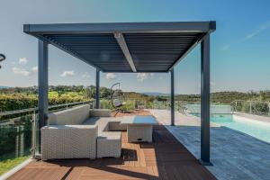 a pergola on a deck next to a swimming pool at Monte da Pechincha - Casa de Hóspedes & Spa in Estremoz