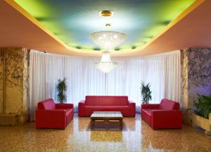 a living room with two red couches and a chandelier at BLUESEA Copacabana in Lloret de Mar
