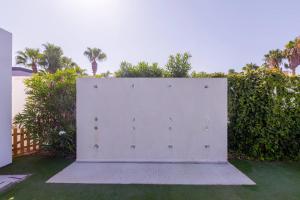 a white wall in a yard next to some bushes at BLUESEA Brisa Roquetas in Roquetas de Mar