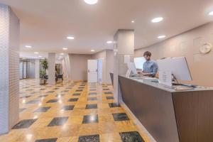 a man sitting at a counter in an office at BLUESEA Brisa Roquetas in Roquetas de Mar +53 photos