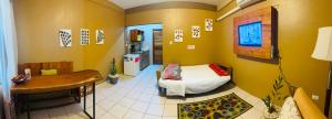 a small room with a bed and a kitchen at City Garden 2 Apartment in Belize City