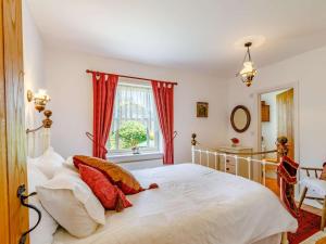 a bedroom with a white bed with red curtains at 2 Bed in Sway oc-nfl43 in Sway