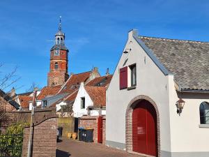 a church with a clock tower in a town at Kade10Buren in Buren