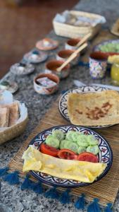 a table with a plate of food with vegetables on it at Blue Tizirin House in Tamraght Ouzdar