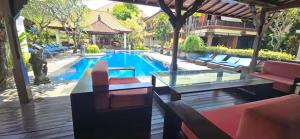a swimming pool with a table and chairs and a swimming pool at Green Cocoon at Bali beach in Sanur +7 photos