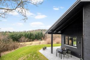 a black house with a patio with a table and chairs at JB408-Brovst-Urbakken-2 in Brovst