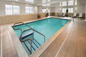 a large swimming pool with blue water in a building at Candlewood Williamsport by IHG in Williamsport