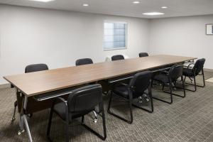 a conference room with a large wooden table and chairs at Candlewood Williamsport by IHG in Williamsport +39 photos
