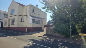 a white house on the side of a street at Clinmore House in Paignton +5 photos