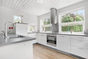 a white kitchen with a sink and two windows at SJ323-Aabenraa-Kloften-14 in Loddenhøj