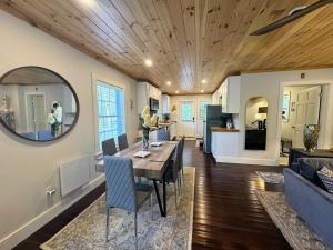 a dining room and living room with a table and a mirror at 3 Bedroom Happy Cottage 15 in Edgecomb