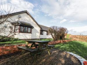 a picnic table in front of a cottage at Summerhill in Hereford