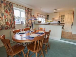 a kitchen and dining room with a wooden table and chairs at Summerhill in Hereford