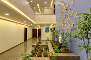 a hallway with potted plants in a building at Hotel Silver Oak 7 Minutes Walk to Mahalaxmi Temple in Kolhapur