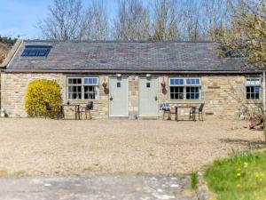 a stone cottage with a table and chairs in front of it at 1 Bed in Hexham oc-82473 in Hexham