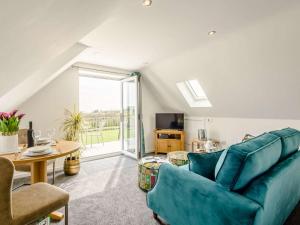 a living room with a blue couch and a table at 1 Bed in Weymouth oc-82098 in Osmington