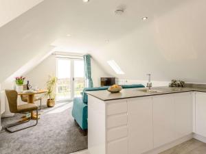 a kitchen with white cabinets and a blue couch in a room at 1 Bed in Weymouth oc-82098 in Osmington