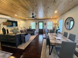 a dining room and living room with a wooden ceiling at 3 Bedroom Happy Cottage 15 in Edgecomb