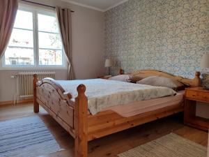 a bedroom with a wooden bed and a window at Näckros in Filipstad