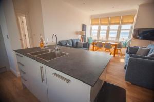 a kitchen with a sink and a living room at Oceanview in Woolacombe