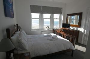 a bedroom with a bed and a desk with a television at Oceanview in Woolacombe