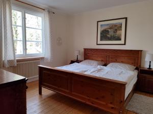 a bedroom with a large wooden bed with white sheets at Skogstjärna in Filipstad