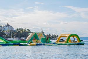 a group of inflatable play structures in the water at MASLINICA Oliva Camping Pitches in Rabac