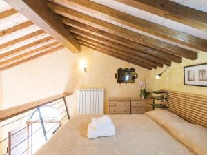 a bedroom with a large bed in a room with wooden ceilings at Apartment Casa Alessandro n-5 by Interhome in Montefiascone