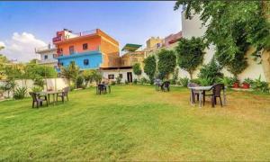 a group of tables in the grass in a yard at Hotel Ashok Palace in Agra