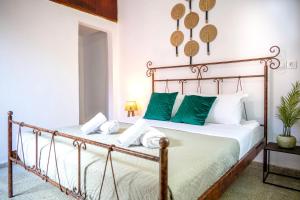 a bedroom with a metal bed with green pillows at Old Town Nest in Rhodes Town +34 photos