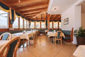 a restaurant with tables and chairs and windows at Residence Fallrohrhof in Naturno