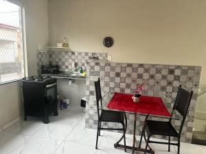 a small kitchen with a red table and chairs at Perfeita casa estilo apartamento in São Luís +8 photos