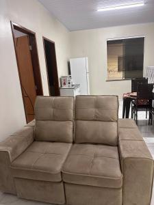 a brown couch in a living room with a table at Perfeita casa estilo apartamento in São Luís