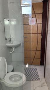 a bathroom with a toilet and a sink at Perfeita casa estilo apartamento in São Luís